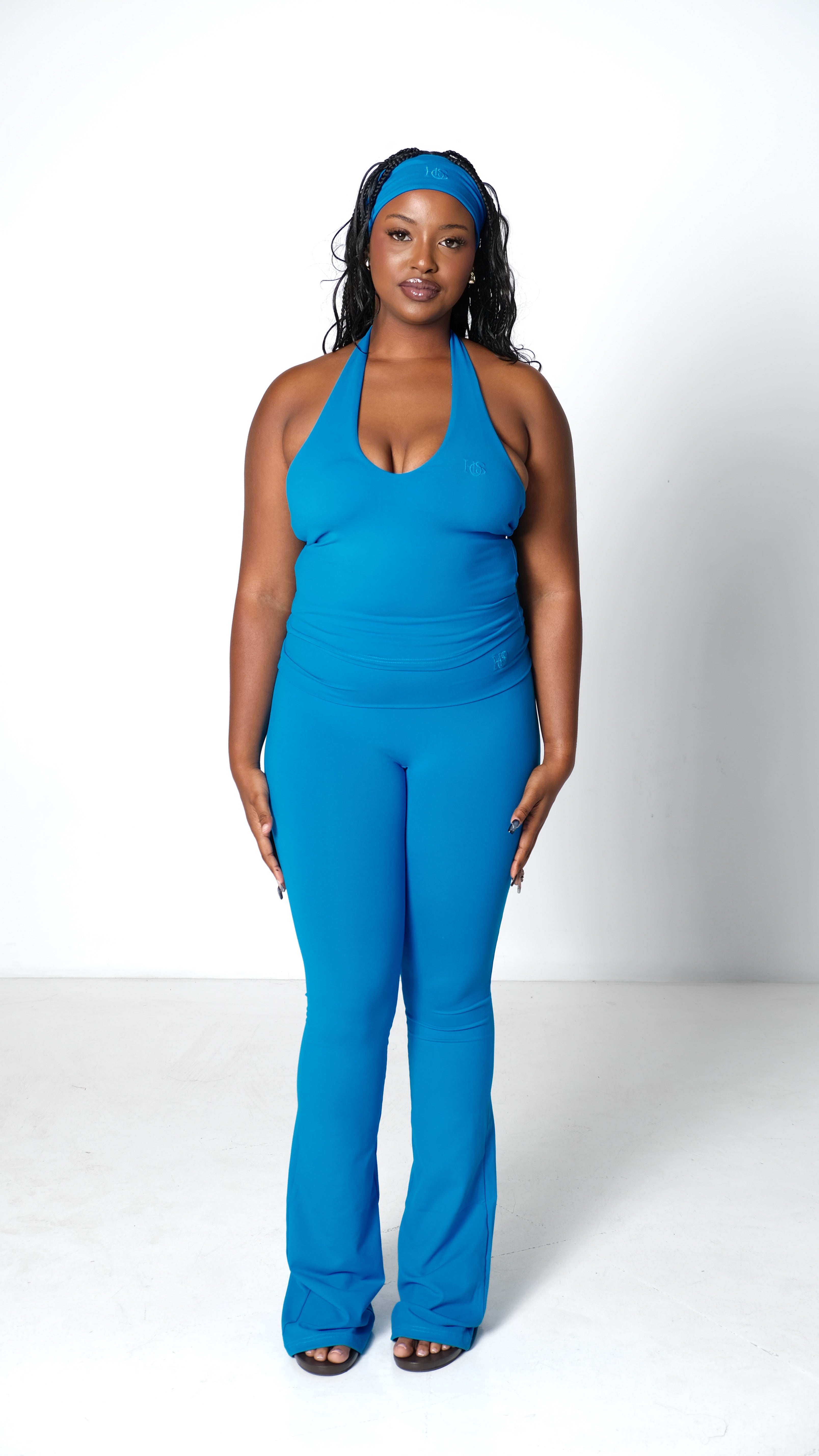 Woman wearing a blue jumpsuit and headband on a white background
